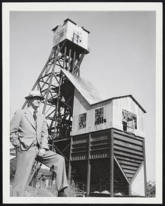 Tarnished Gold. Mark Eudey stands in front of the frame of the once rich Kennedy gold mine in Jackson, Calif. Eudeu owns the mine. But he bought it for the 600 acres of rolling land he got with it. Eudey, now 70, was superintendent of the mine when it was one of the big producers of Amador County. Before it was shut down in 1942, Kennedy produced 45 million dollars in gold ore. Now it lies neglected, probably still rich in ore but not worth the cost of mining it. Throughout Amador County, mine frames stand as neglected reminders of the years after California's Gold Rush. Those years live in the pages of Mark Twain, Bret Harte and other writers. The mines lived on after the romantic period of the writers' stories was dead. And then the mines died, too. With cost of materials and wages more than doubled, Eudey doubts whether the miner's day will return in Amador County. The gold may still be there for the working, but the golden prospects are tarnished.