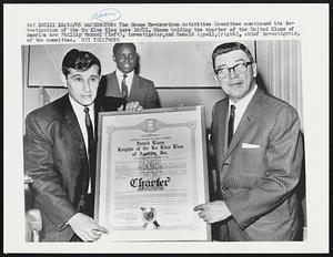 The House Un-American Activities Committee continued its investigation of the Ku Klux Klan here 10/21. Shown holding the charter of the United Klans of America are Phillip Manuel (left), investigator, and Donald Appell, (right), chief investigator, of the committee.