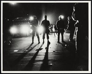Night scene, headlights shining toward standing people