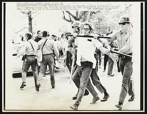 College Park, MD.: University of Maryland students protesting the sending of American troops into Cambodia vandalized the ROTC offices 5/1. Here, riot equipped State Police take one of the protesters into custody. Demonstrations Anti-War.