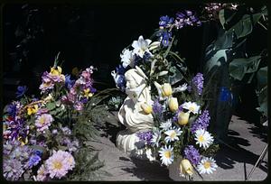 Flower arrangements surrounding a statue