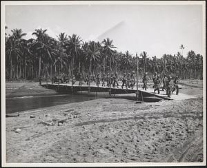 Moving across a bridge constructed by marine engineers on Guadalcanal
