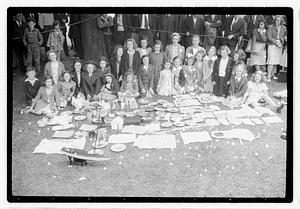A group of girls behind a collection of items