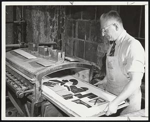 Firing Painted Parts of glass in gas-fired kiln to set colors is Fred Joergens of Roslindale.