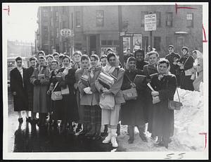 Crowd of girls stands on Dudley St., near Greenville St., Roxbury, today for bus to take them to Roxbury Memorial High School for Girls Boston schools reopened for first time since Friday.