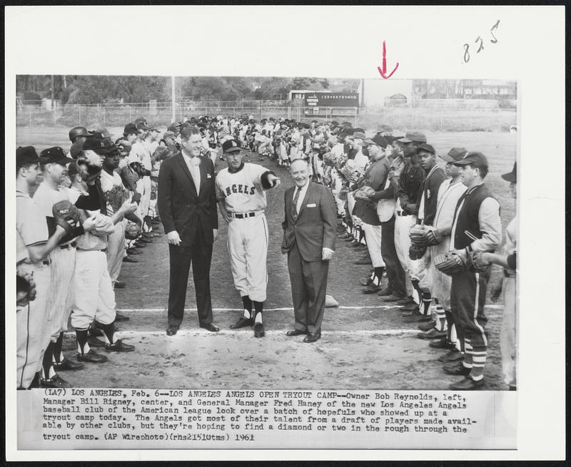 Los Angeles Angels Open Tryout Camp - Owner Bob Reynolds, left, Manager Bill Rigney, center, and General Manager Fred Haney of the new Los Angeles Angels baseball club of the American league look over a batch of hopefuls who showed up at a tryout camp today. The Angels got most of their talent from a draft of players made available by other clubs, but they’re hoping to find a diamond or two in the rough through the tryout camp.