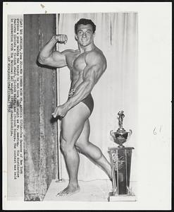 New Yorker Wins Mr. America Title--Tom Sansone of New York strikes a pose beside the trophy he won here last night as Mr. America. His distinctice features include a 51-inch chest, 31-inch waist, and 19-inch biceps. The contest was held in connection with the National AAU weight lifting championships.