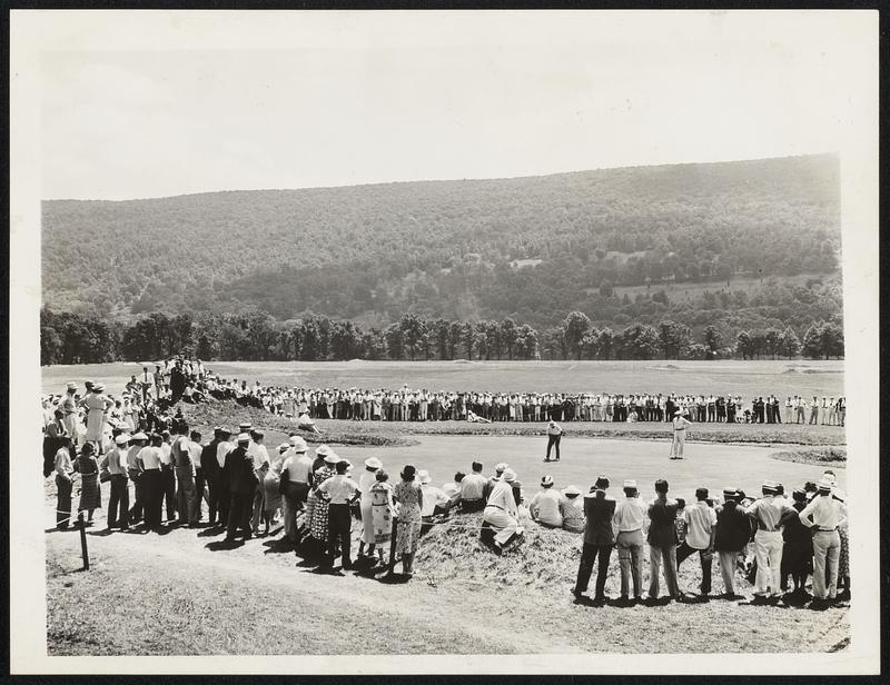 Shawnee-on-Delaware, Penna.--Paul Runyan, who defeated Sam Snead 8 and 7 in the P.G.A. championship today, is shown sinking a putt on the 15th green as the large gallery watches.