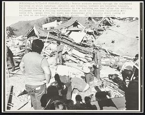 Rescue workers search through the collapsed building in which numerous patients and hospital workers are believed trapped. First reports say that seven patients in the building are dead after the building collapsed during a rolling earthquake that shook the Southern California area early 2/9. Damage from the quake was widespread with reports still coming in as late as six hours after the first shock.