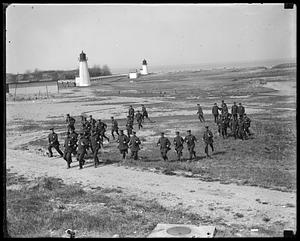 A group of police, some running, on a beach