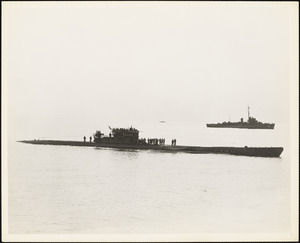 The Third undersea vessel to surrender U-1228 glides into Portsmouth NH early dawn of May 17, 1945 while the DE to which she surrendered [hovers] watchfully in the background