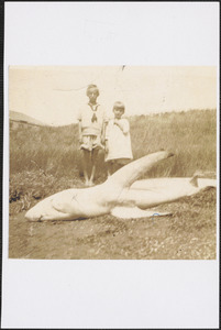 Doris Schirmer and brother Gardner standing with a shark that washed ashore