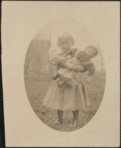 Informal portrait of a young girl with a doll