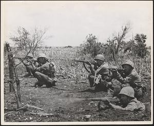 Marines mopping up Tinian Island drop into firing positions when the enemy is sighted