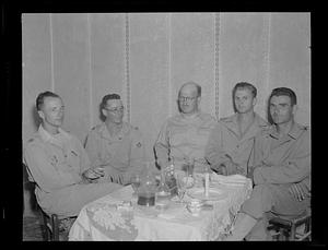 Group of men in uniform seated at table