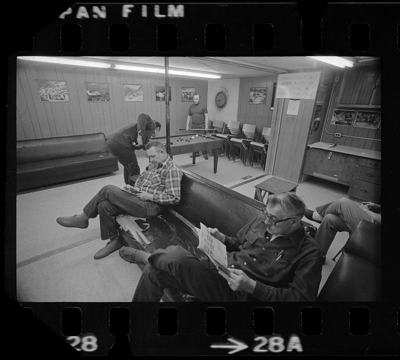 Men read and play pool in recreation hall, North Slope camp, Anchorage, Alaska