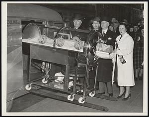 Iron Lung Exhibited in Paralysis Campaign. A transparent iron lung was installed in the Information Center window today at Park Ave. and 42nd Street as part of the "Fight Infantile Paralysis" campaign. In the iron lung will be "Annie" the breathing doll. The lung arrived today from Boston on a trailer towed behind an automobile, illustrating how iron lungs are rushed to epidemic areas. This photo taken at the Information Center today. Left to right:- Edmond B. Butler, Greater New York Chapter National Foundation for Infantile Paralysis, Warren E. Collins, Jr., of Boston, Col. D. Walker Wear, Greater New York Chairman for the "Fight Infantile Paralysis Campaign" and Miss Mary McCarthy, attendant.