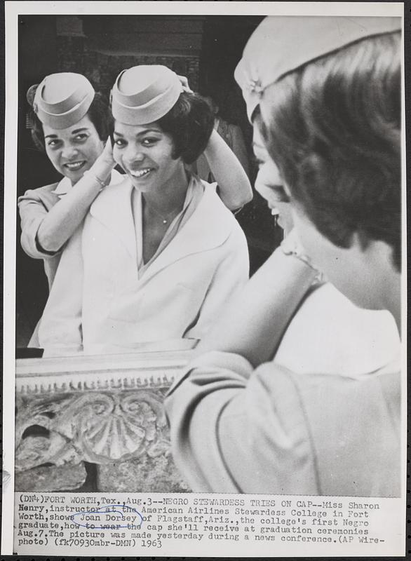 Negro stewardess tries on cap