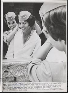 Negro stewardess tries on cap
