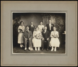 Seated bride and groom with six attendants