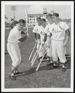 The Man Shows ‘Em. Stan (The Man) Musial shows four of his outfielding mates on St. Louis Cardinals he form that puts fear into the hearts of National League pitchers when he steps up to the plate. Admiring quartet just before Mar. 2 workout at Cards’ St. Petersburg, Fla., spring training base, includes, from left, rookies Bill Virdon and Harry Elliott and regulars Rip Repulski and Wally Moon.