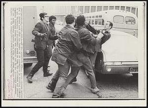 On the Receiving End-- A plain clothes police man is forced back over the fender of an automobile as striking students at the University of California pound on him. The policeman had pursued students throwing rocks and was singled out by the dissident students and put upon. Twenty arrests were made and three police officers injured in the fray.