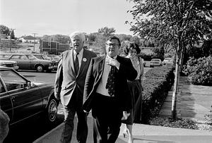 Politicians walking on a sidewalk