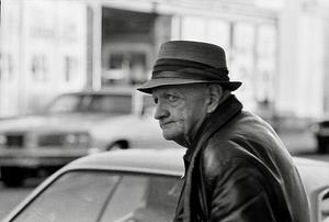 Old man on street looking out