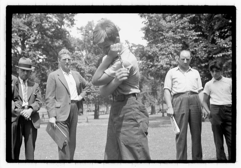 An audience looking at a boy holding a knife