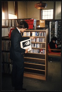 Newton Free Library, Newton, MA. Staff & trustees. Patron reading titles of CDs
