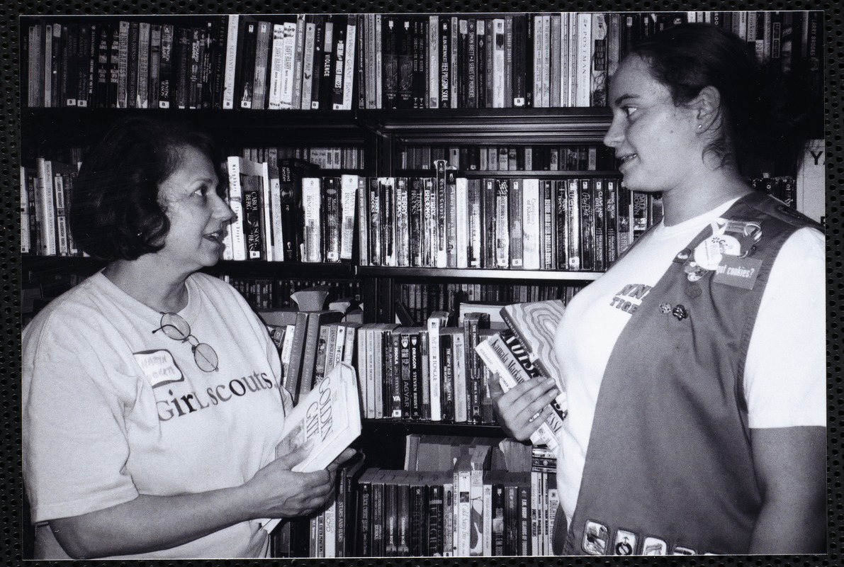 Newton Free Library, Newton, MA. Communications & Programs Office. Girl Scout, leader, at stacks