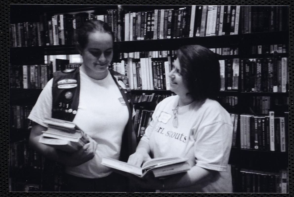 Newton Free Library, Newton, MA. Communications & Programs Office. Girl Scout, leader, at stacks