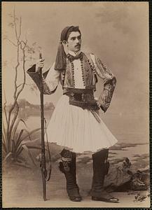 Studio portrait of man in traditional Greek dress with rifle