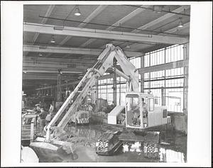 Interior with bulldozer, employees in background