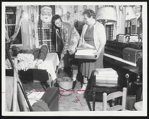 Saugus Mop Up - Mrs. Joseph Collette, right, whose house at 22 Milton St., Saugus, was flooded for the first time in 35 years by an overflowing Saugus River, gets a helping hand from her daughter and neighbor, Mrs. James Gudaites. Their dwellings were among more than 100 houses in the area flooded.