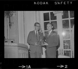 Secor D. Browne, left, chairman of the Civil Aeronautics Board, presents the Godfrey L. Cabot award to Astronaut Alan L. Bean, a member of the crew of Apollo 12, during the Aero Club of New England annual dinner held yesterday at the Sheraton Plaza Hotel