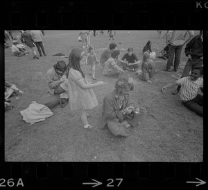 Hippie on the Boston Common blowing bubbles with a girl looking on