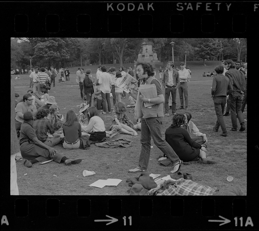 Man passing out copies of the "Boston Free Press" during hippie occupation of the Boston Common