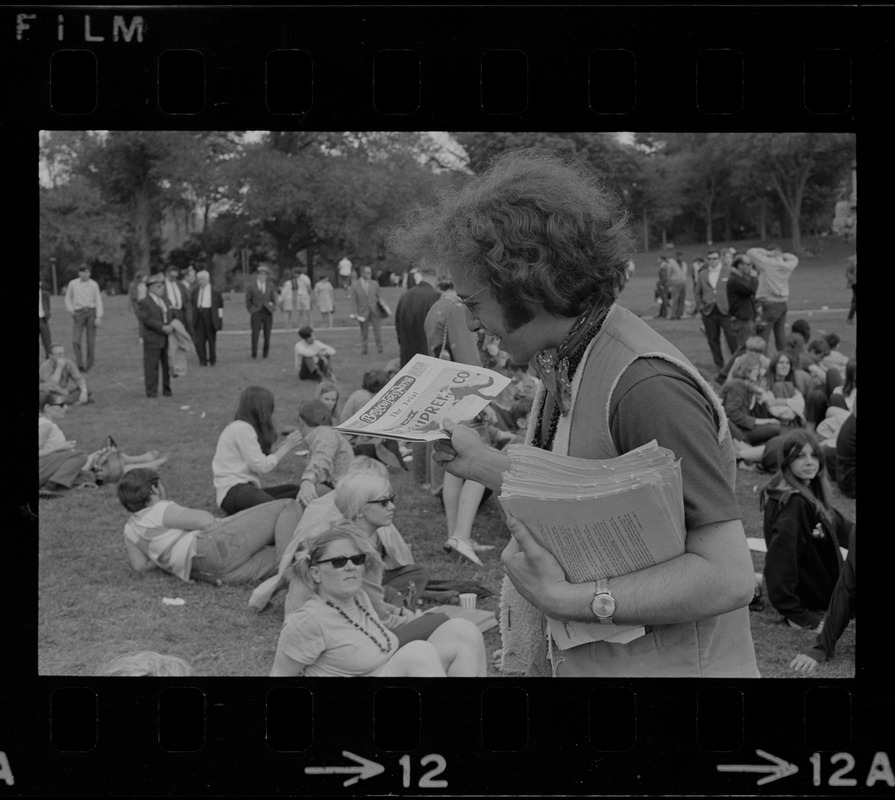 Man passing out copies of the "Boston Free Press" during hippie occupation of the Boston Common