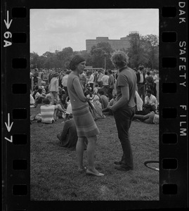 Female photographer speaking with a hippie on the Boston Common