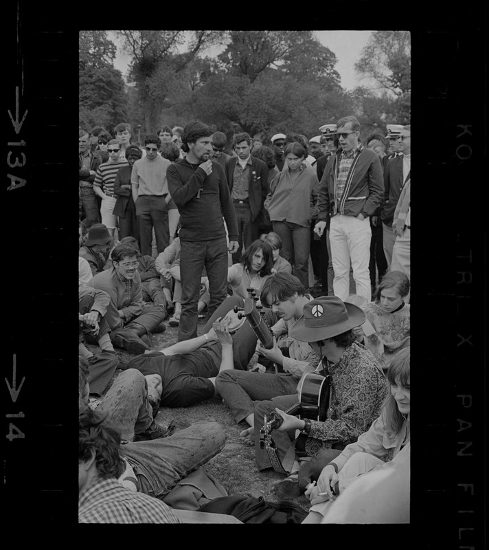 Spectators gathered around hippies playing music on the Boston Common