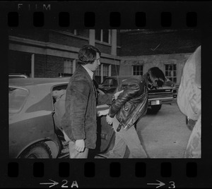 Man being led out of a car