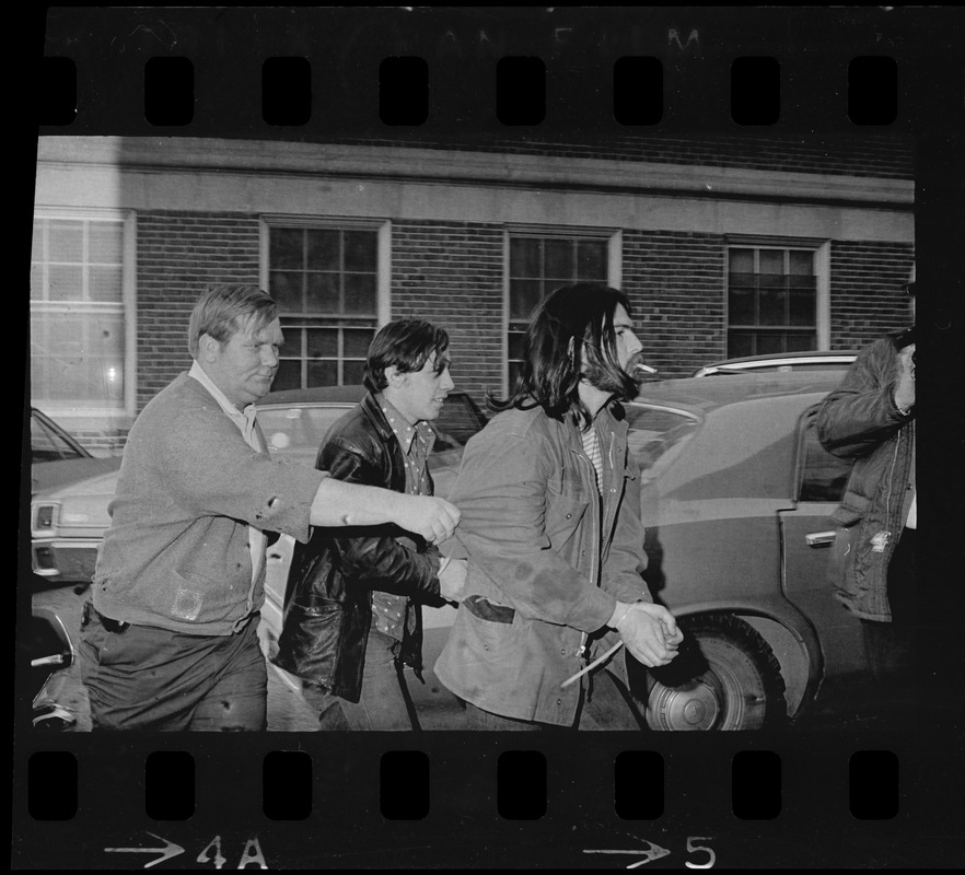 Man in police custody being led from car