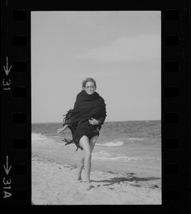 Faye Dunaway walking along a beach