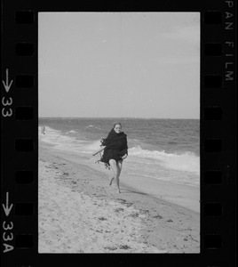 Faye Dunaway walking along a beach