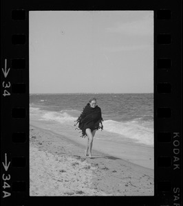 Faye Dunaway walking along a beach