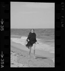 Faye Dunaway walking along a beach