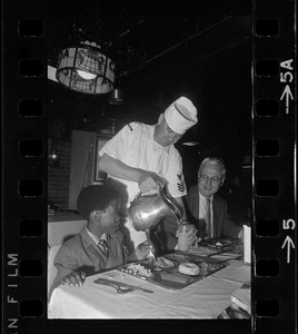 Guest of the United States Navy aboard the Aircraft carrier USS Intrepid in Boston Harbor, Riki Jackson of Dorchester is served by First Class Commissaryman John Oaks