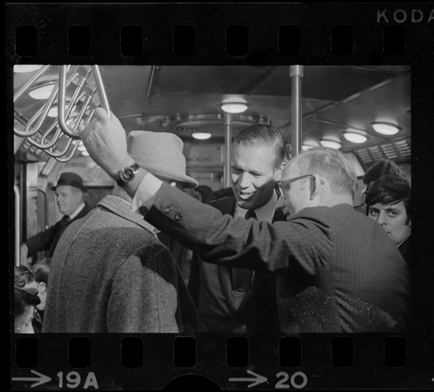 New MBTA Board Chairman, Dr. Robert C. Wood, with fellow commuter Gov. Sargent straphanging on train nearing Columbia Station