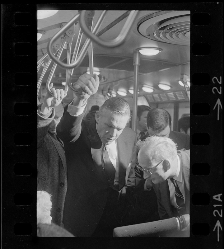 New MBTA Board Chairman, Dr. Robert C. Wood, with fellow commuter Gov. Sargent straphanging on train nearing Columbia Station